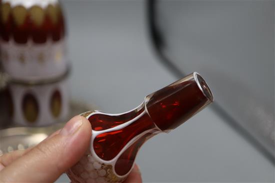 A plated three bottle tantalus, the decanters overlaid glass with gilt decoration, height 37cm